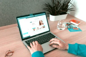 osoba pisząca na laptopie na stole