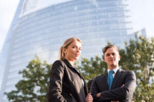 Jakie konto firmowe wybrać na start w 2025? Analiza i porady Businessman and businesswoman, buildings in background, London,