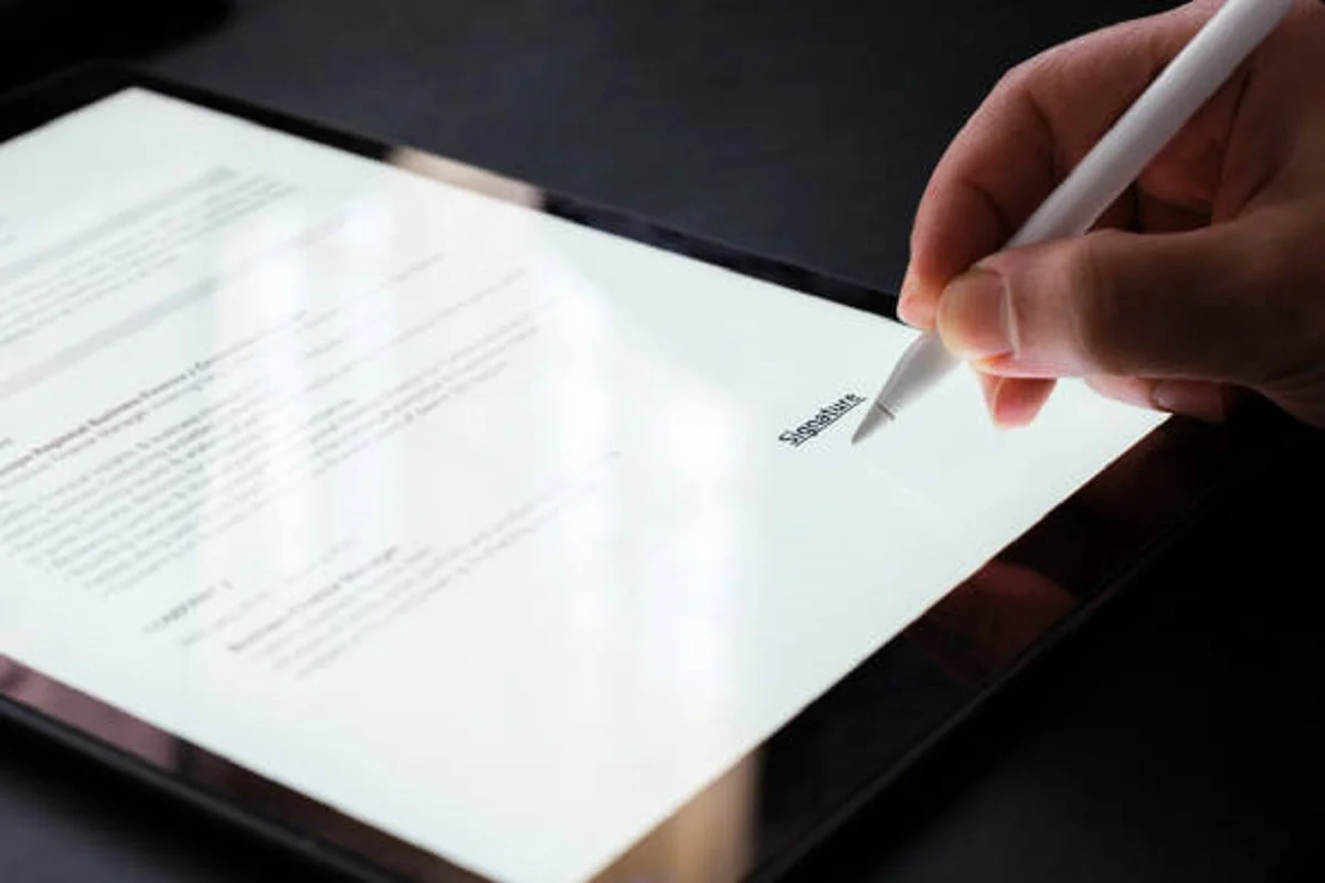 Biznesmen podpisujący umowę elektroniczną na tablecie cyfrowym