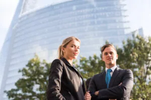 Businessman and businesswoman, buildings in background, London,
